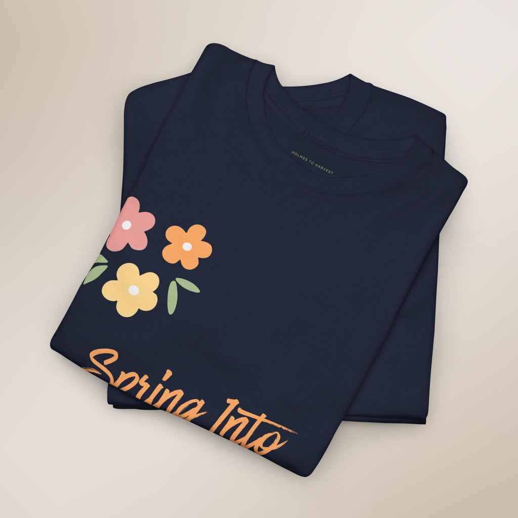 Black t-shirt with colorful floral design and 'Spring Into' text on a beige background
