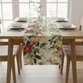 Dining table set with a floral table runner in a bright room.