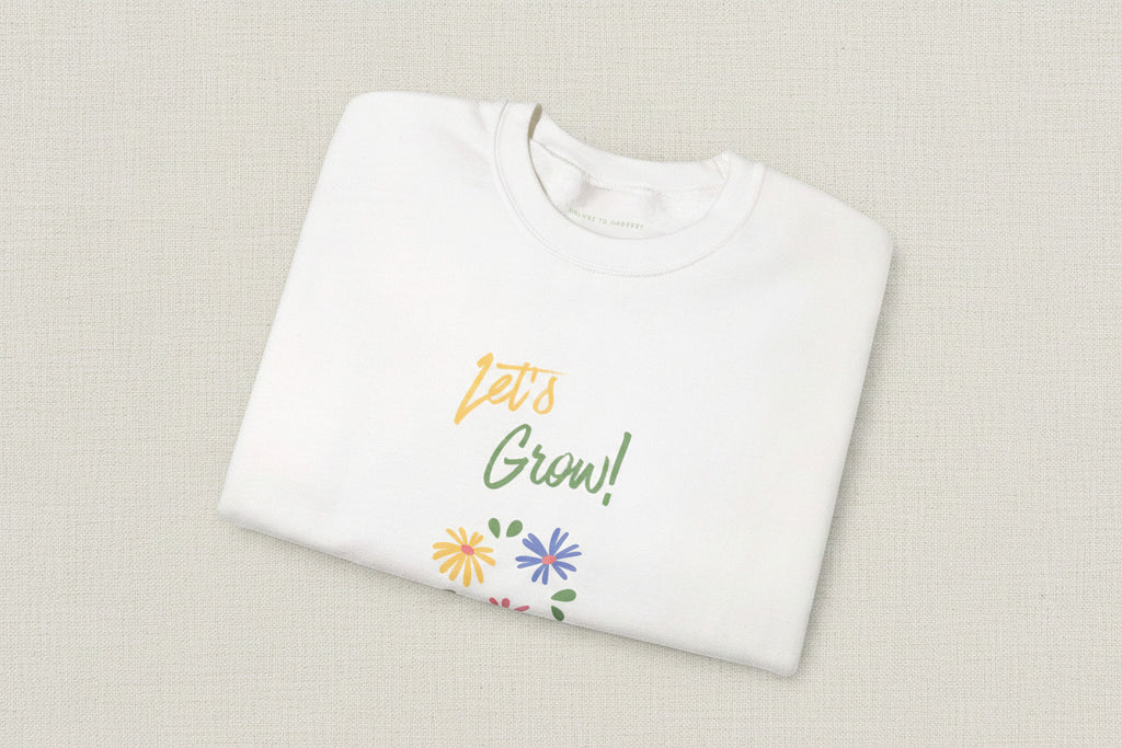 White shirt with 'Let's Grow!' text and floral designs on a white background
