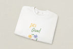 White shirt with 'Let's Grow!' text and floral designs on a white background