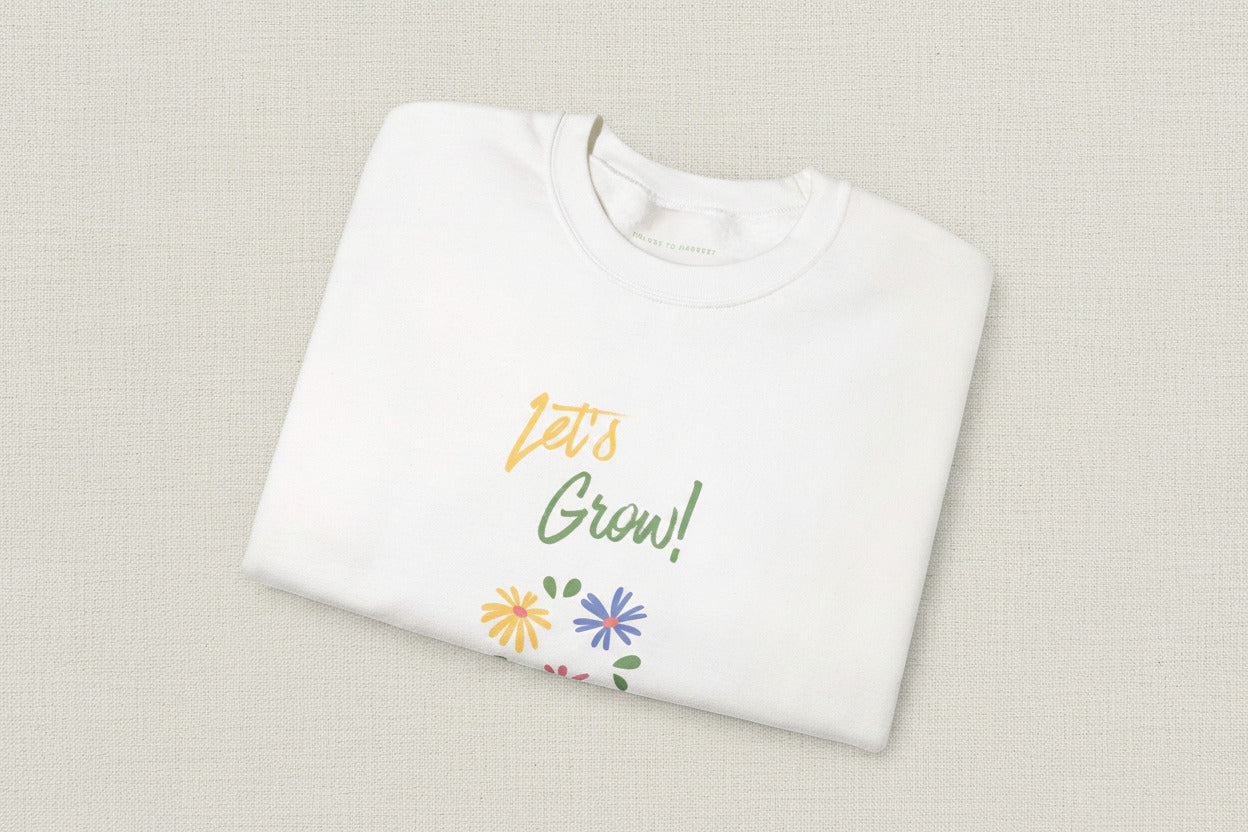 White shirt with 'Let's Grow!' text and floral designs on a white background