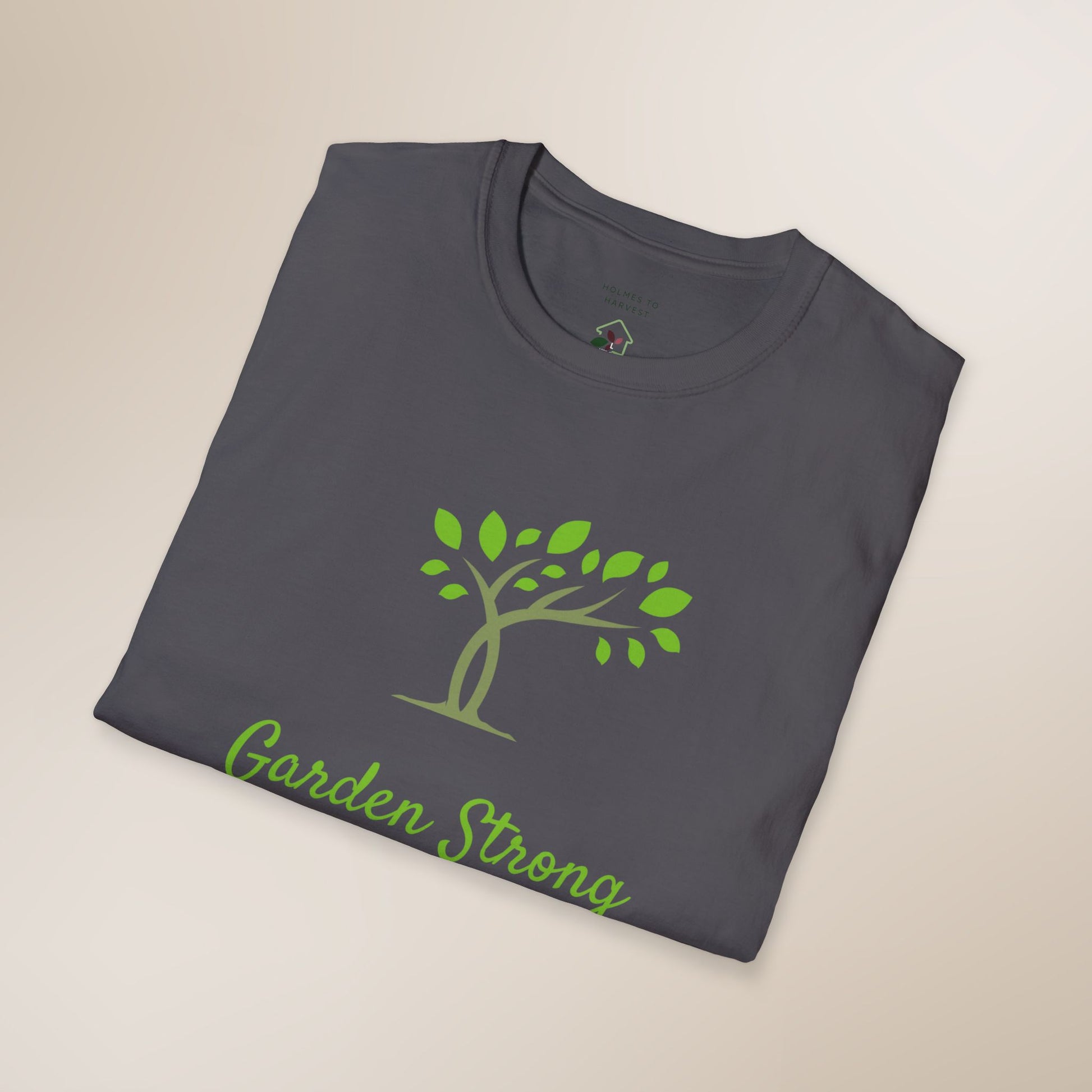 Folded gray t-shirt with green tree and 'Garden Strong' text on a beige background