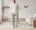 Man wearing patterned pajama pants standing in a living room.
