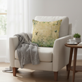 Beige armchair with a decorative pillow and a cup on a small table in a bright room.