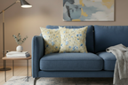 Blue sofa with floral cushions in a living room setting