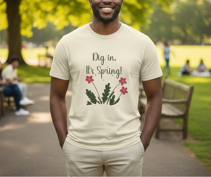 Man wearing a t-shirt with 'Dig in, It's Spring!' text and floral design in a park setting.