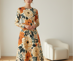 Woman wearing a floral dress in a room with a white chair.