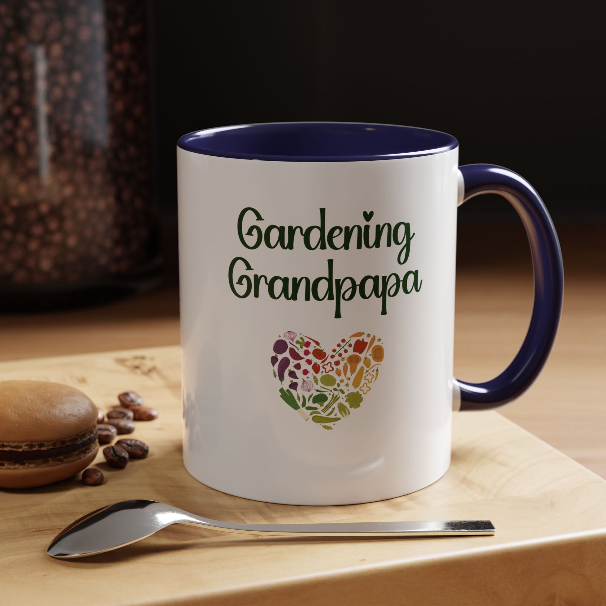 Mug with 'Gardening Grandpapa' text and heart design on a wooden surface with coffee beans and a spoon.