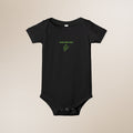 Black baby onesie with green text and leaf design on a beige background