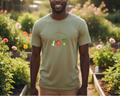 Man wearing a light green t-shirt with vegetable graphics in a garden setting