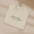 Folded beige t-shirt with text on a beige background