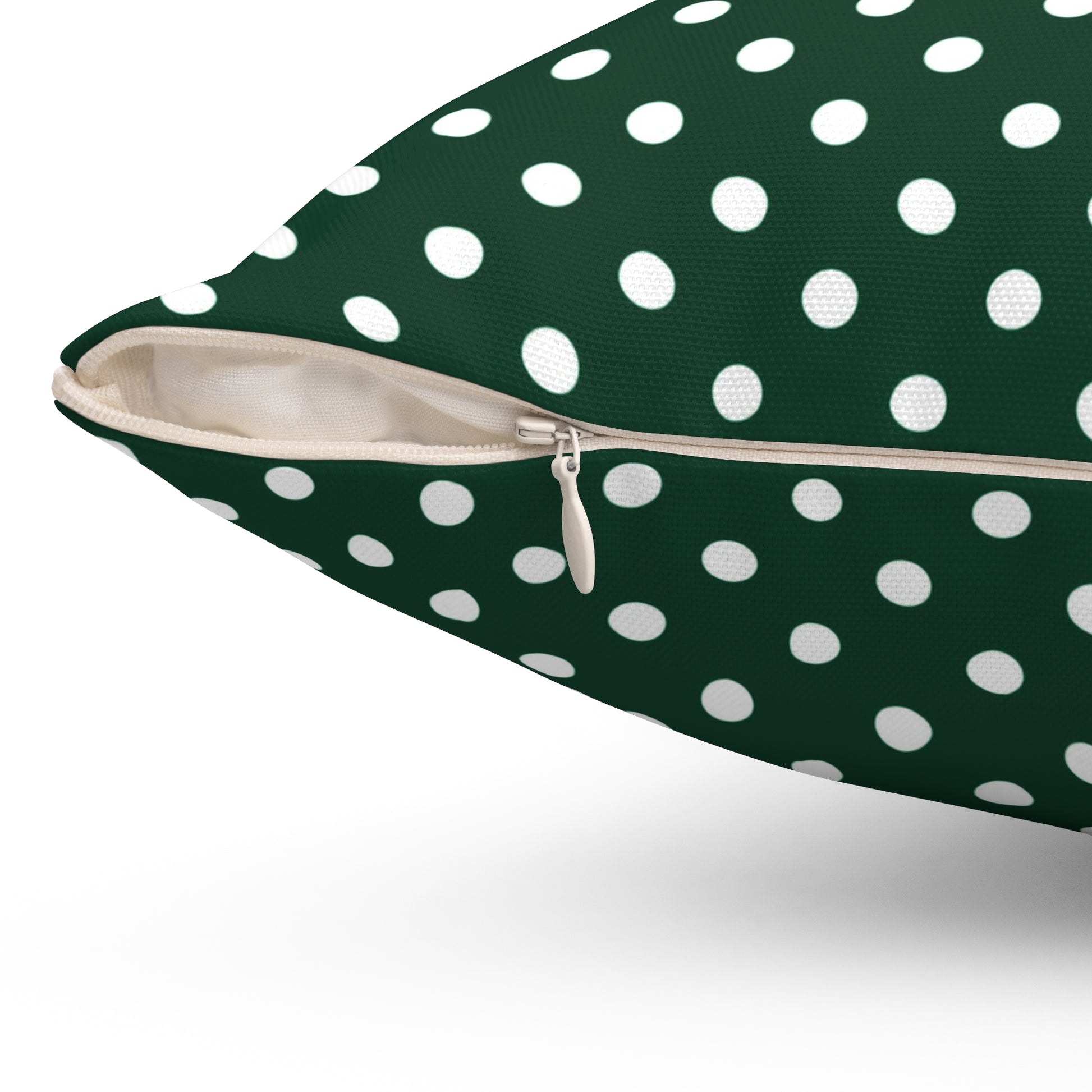 Green pillow with white polka dots on a white background