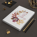 Notebook with 'Fall Gardening' design on a dark surface with stationery items.