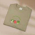 Folded green t-shirt with 'Gardening Rocks' text and vegetable graphics on a beige background