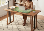 Person using a laptop on a wooden desk in a home office setting