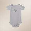 Gray baby onesie with 'Grow a Little, Cheer a Lot' text on a beige background