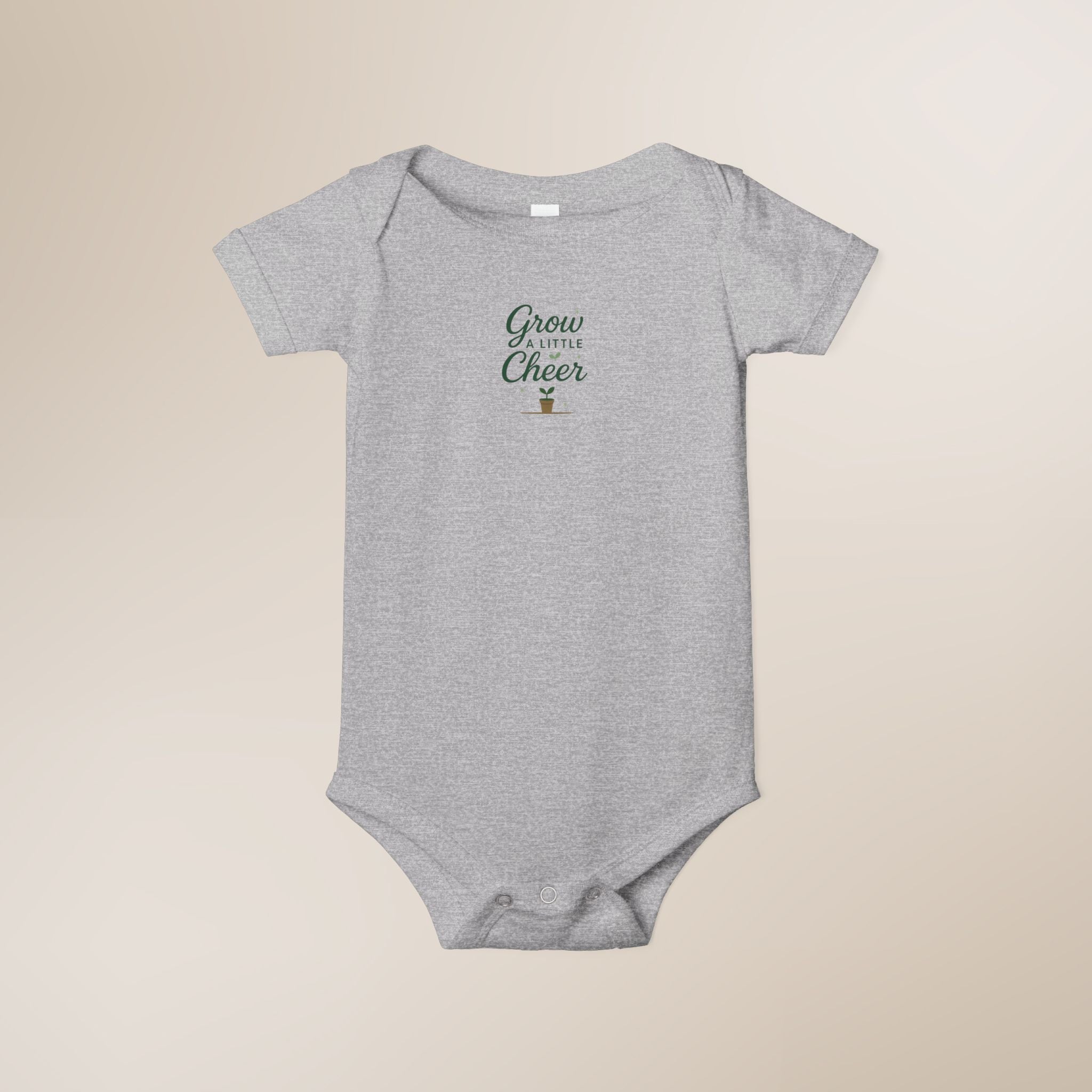 Gray baby onesie with 'Grow a Little, Cheer a Lot' text on a beige background
