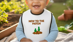 Child wearing a shirt with 'New to the Patch' text and cactus graphics in an outdoor setting.