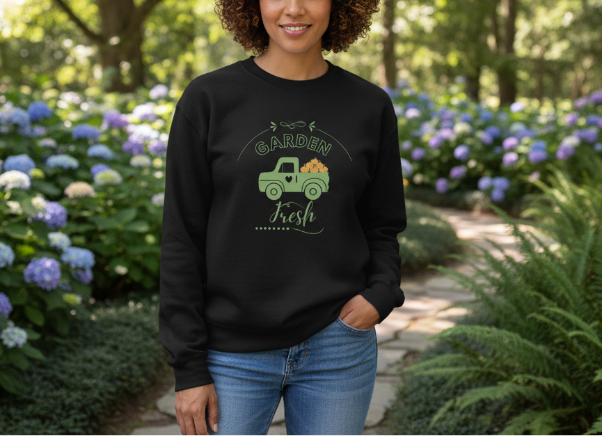 Person wearing a black sweatshirt with a graphic design in a garden setting