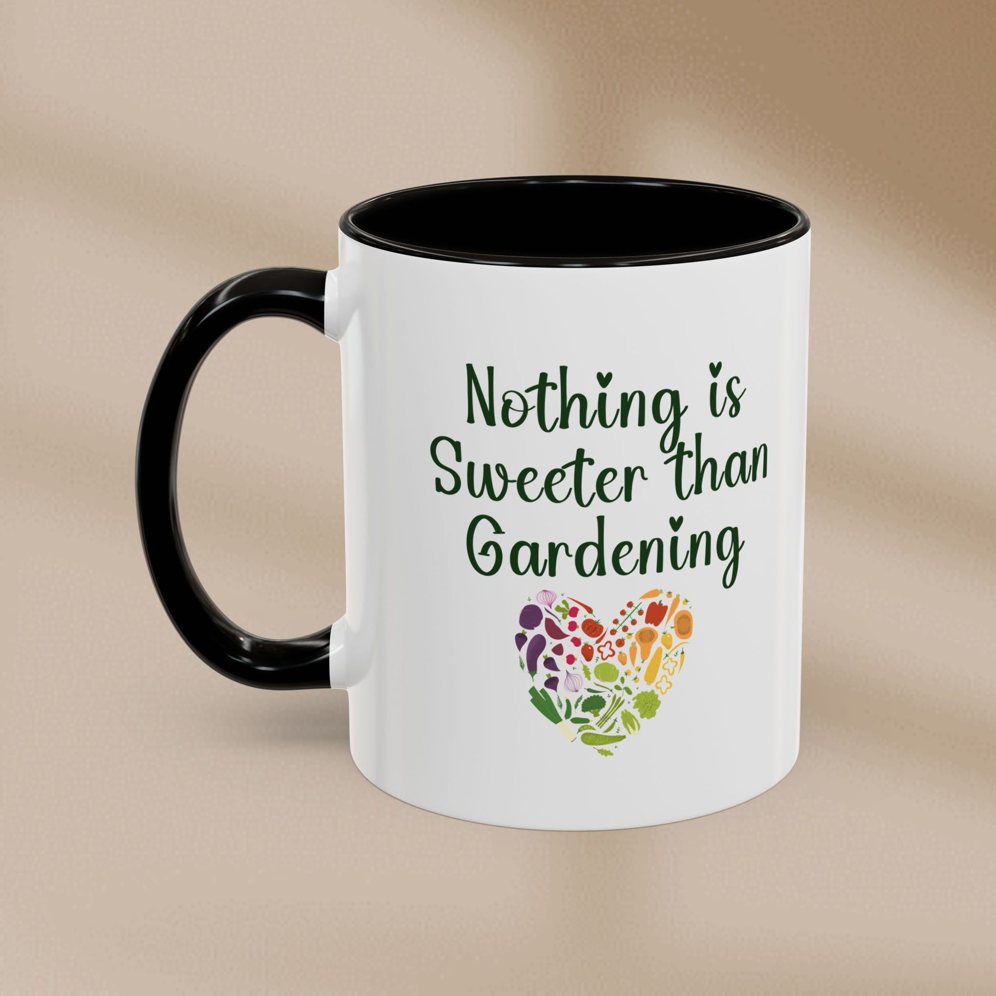 White mug with black handle featuring 'Nothing is Sweeter than Gardening' text and colorful heart design on a beige background.