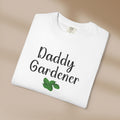 White t-shirt with 'Daddy Gardener' text and green leaf design on a beige background