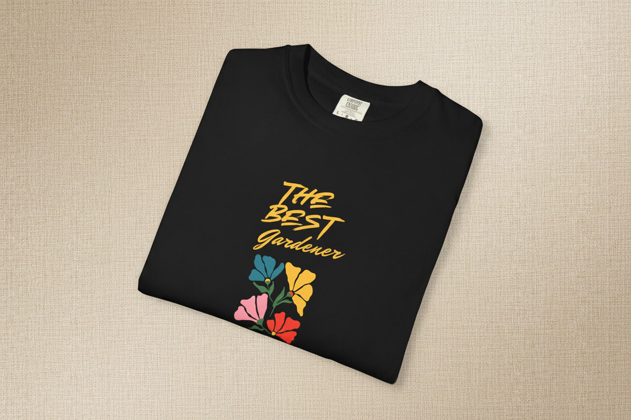 Black t-shirt with 'The Best Gardener' text and colorful flowers on a beige background