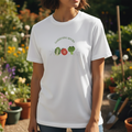 Person wearing a white t-shirt with 'Gardening Rocks' design in a garden setting