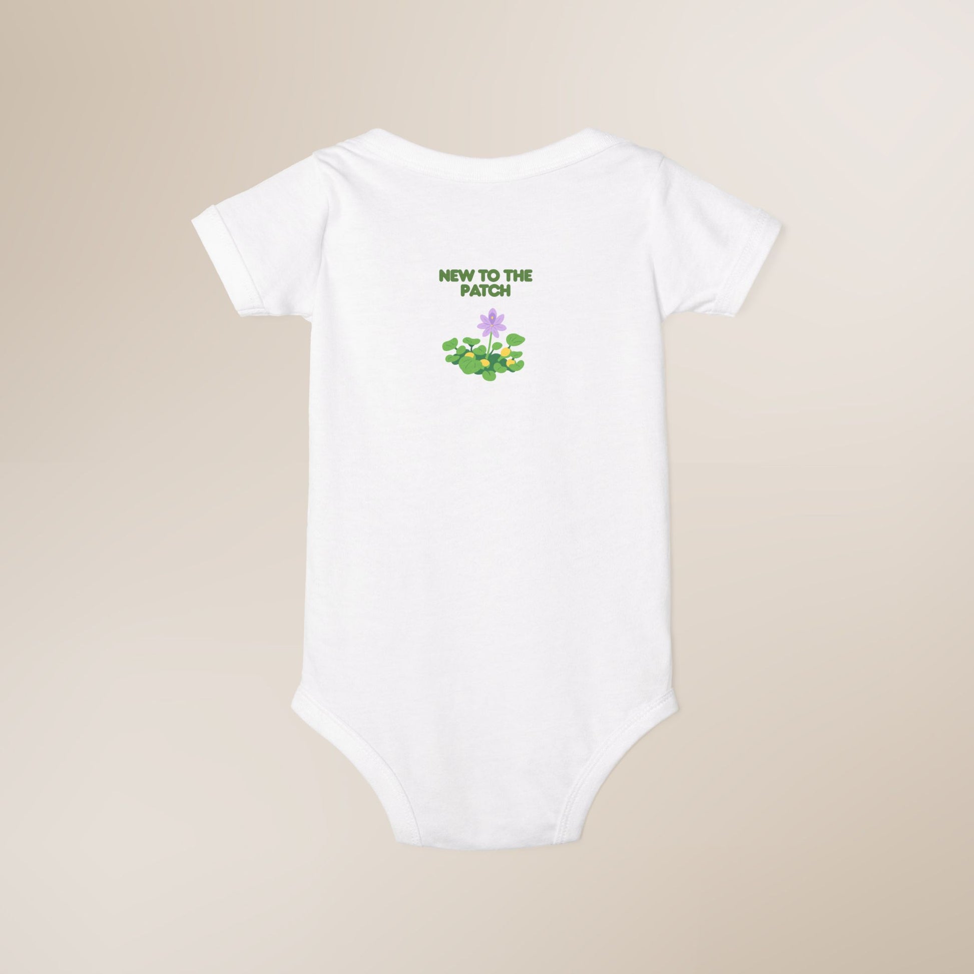 White baby onesie with 'New to the Patch' text and graphic on a beige background