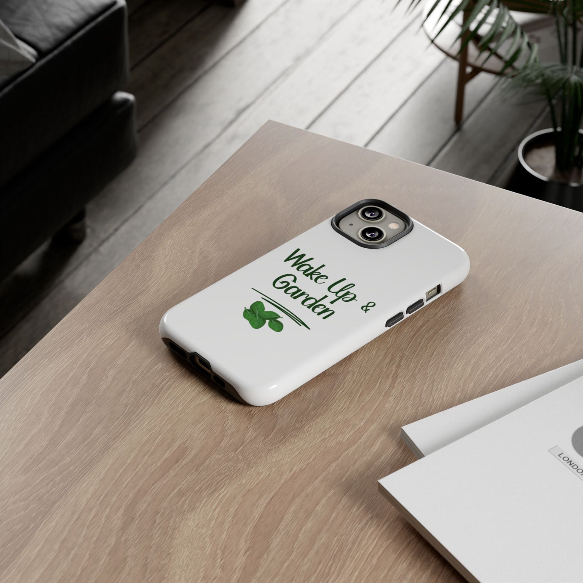 Phone case with 'Wake Up & Garden' text on a wooden surface