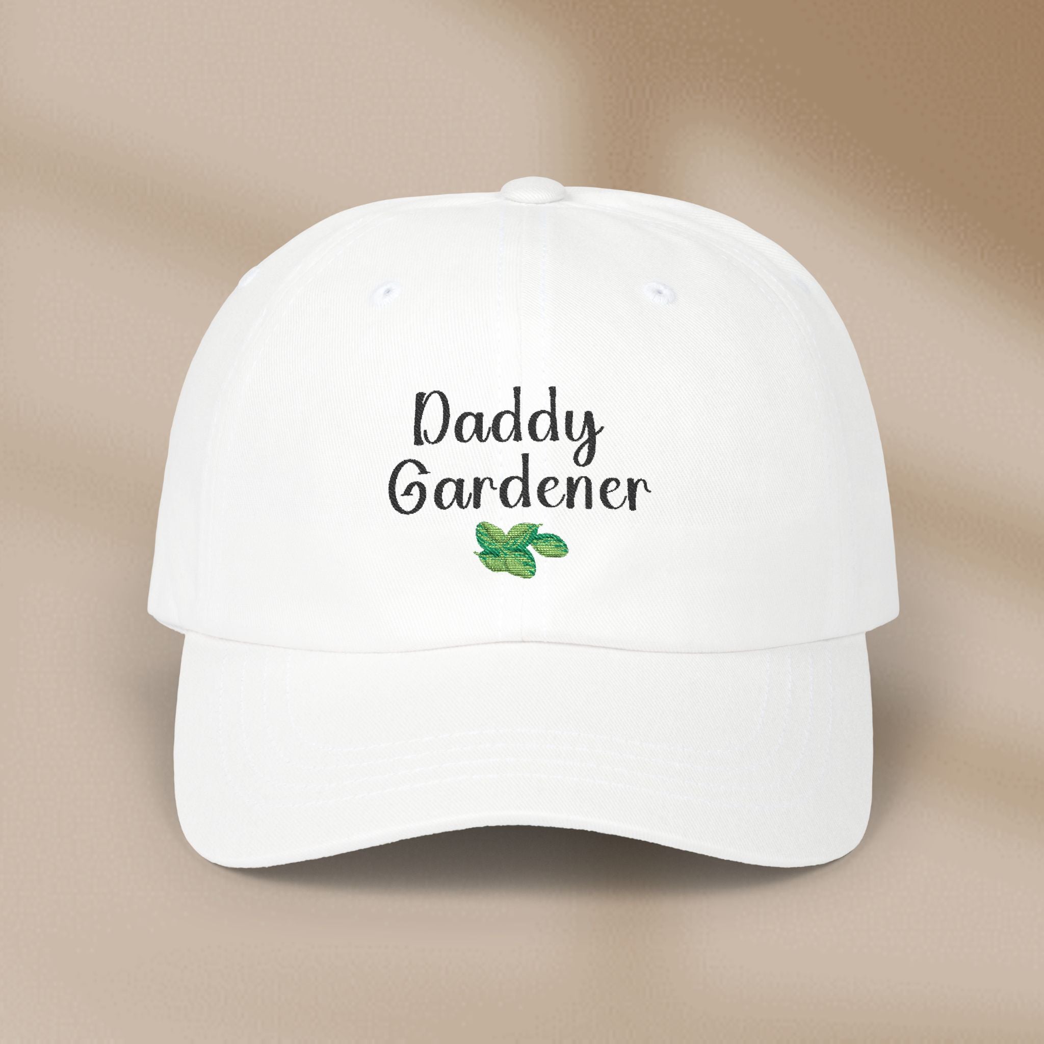 White cap with 'Daddy Gardener' text and leaf design on a beige background
