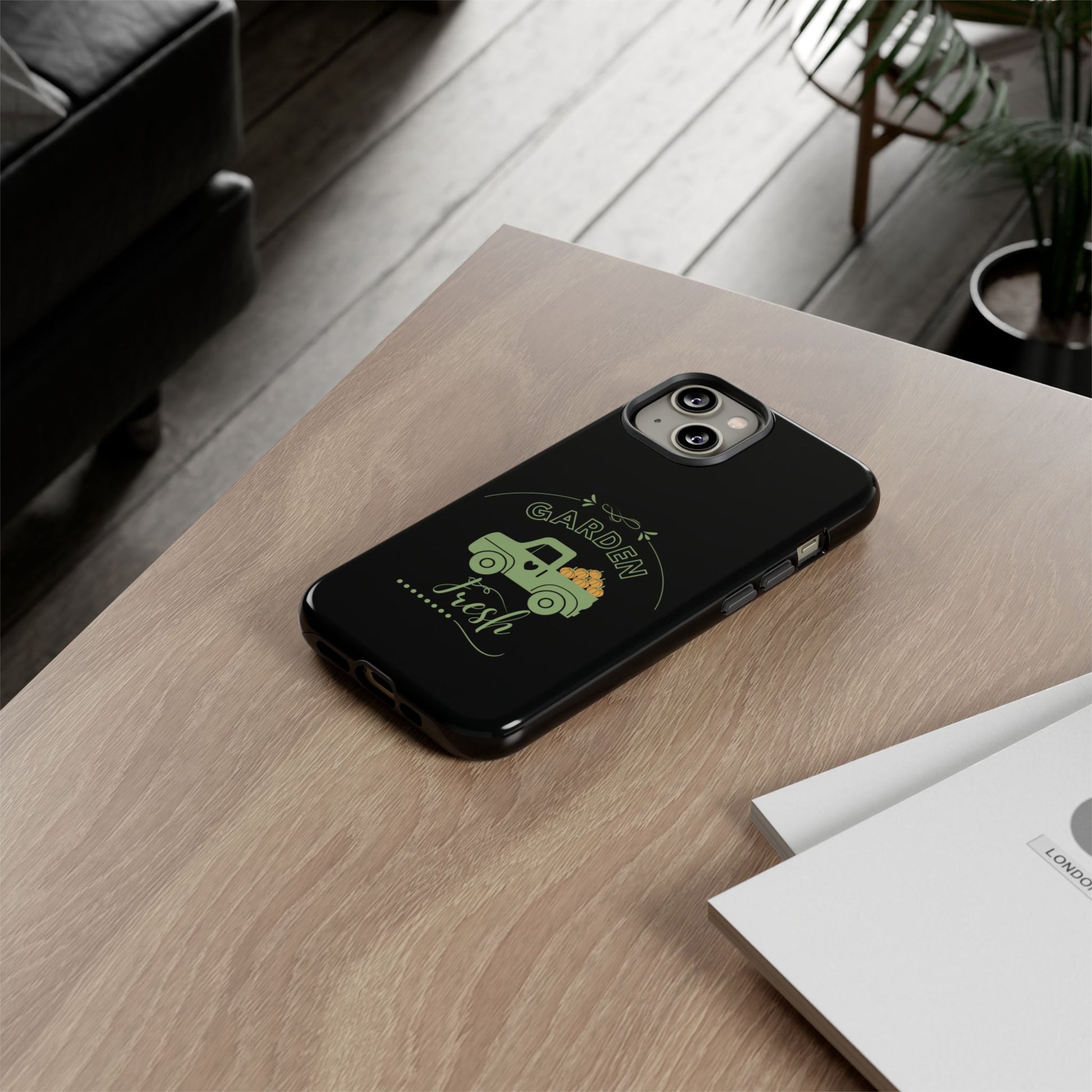 Black phone case with green design on a wooden table