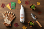 Gardening tools and accessories on a wooden surface with fall leaves