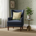Navy blue armchair with a decorative pillow in a room with a plant and side table.