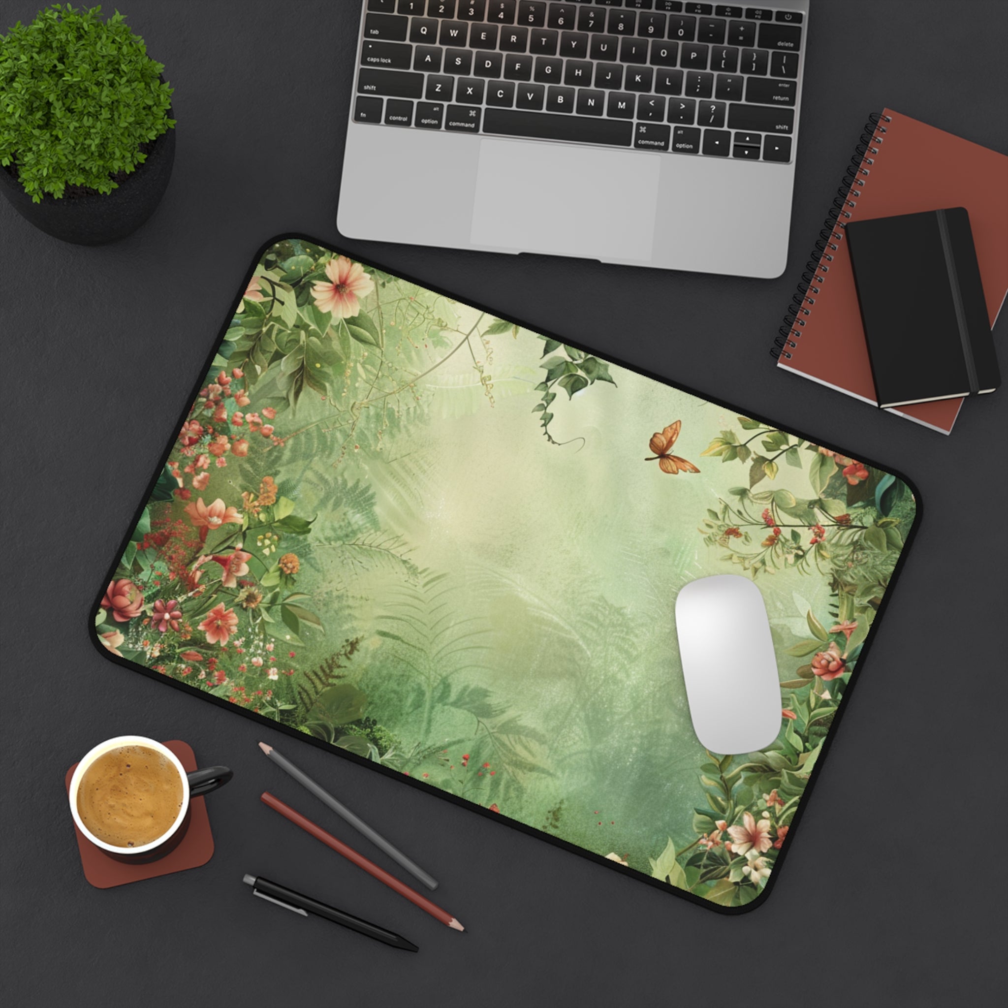 Floral mouse pad on a desk with a laptop, notebook, and cup of coffee.