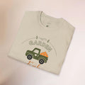 Folded t-shirt with a graphic of a truck and 'Garden' text on a beige background