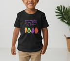 Child wearing a black t-shirt with colorful vegetables and text, standing against a light background.