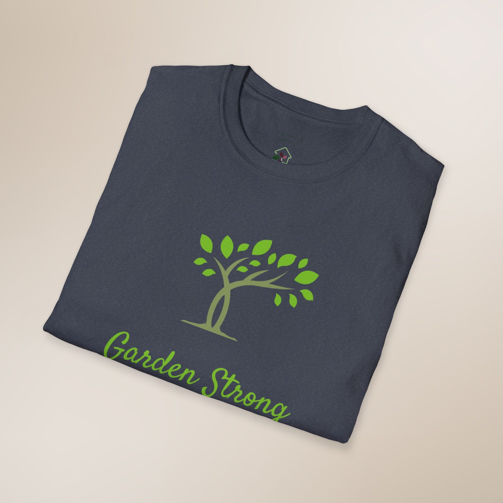 Folded navy blue t-shirt with green tree and 'Garden Strong' text on a beige background