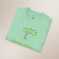 Folded green t-shirt with 'Garden Strong' design on a beige background