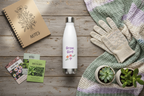 Gardening-themed items including a water bottle, gloves, and plant seed packets on a wooden surface.