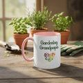 Mug with 'Gardening Grandpapa' text and heart design on a wooden table with plants and gardening tools.