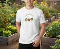 White t-shirt with gardening-themed design on a beige background