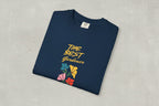 Folded navy blue t-shirt with 'The Best Gardener' text and floral designs on a beige background