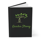 Black notebook with 'Garden Strong' and tree design on a white background