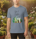 Person wearing a blue t-shirt with a garden-themed design in a garden setting