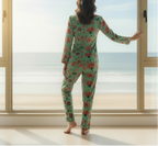 Person wearing a floral pajama set standing by a large window with a view of water.