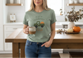 Woman wearing a green t-shirt with a truck graphic in a kitchen.