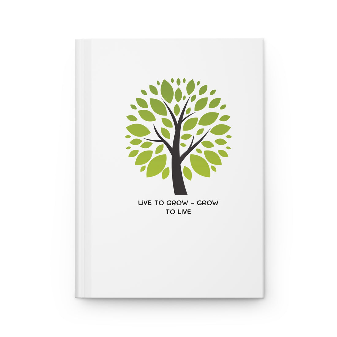 Book with a green tree design and text on a table with a cup and notebook.