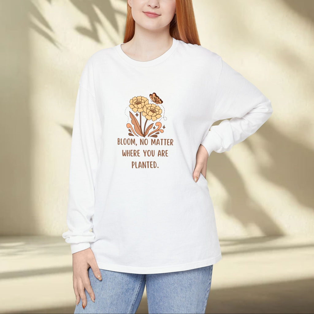 Person wearing a white sweatshirt with a floral design and text, standing against a neutral background.