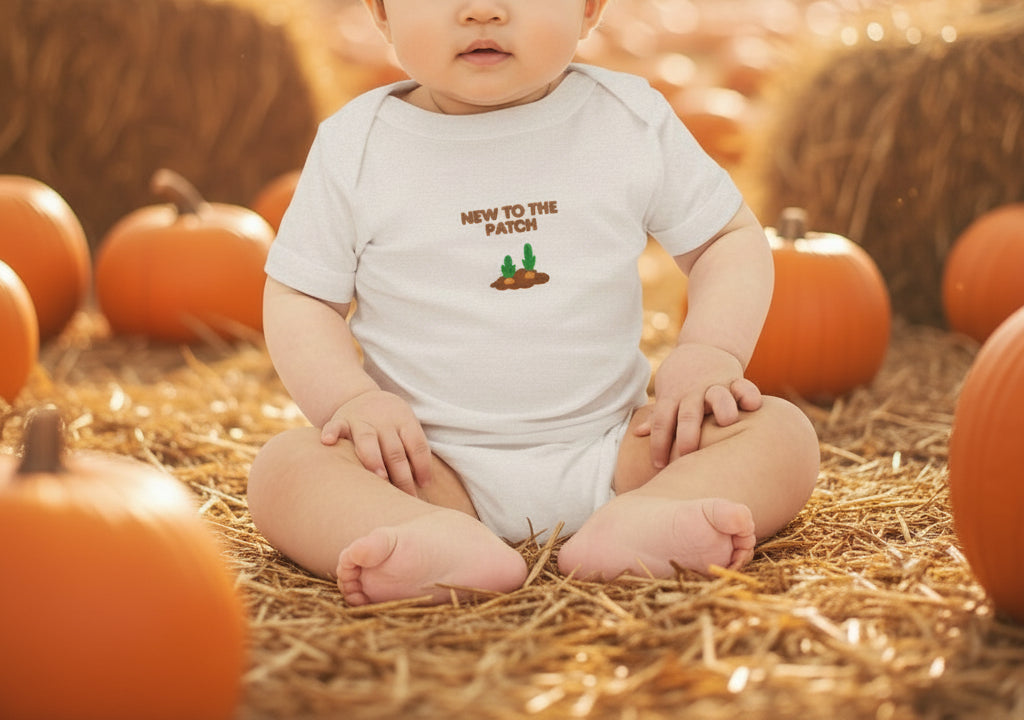 Baby wearing a onesie with 'New to the Patch' text and graphics on a beige background