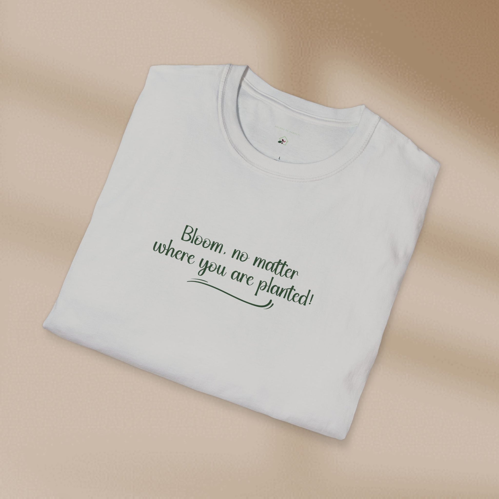 Folded white t-shirt with text on a beige background